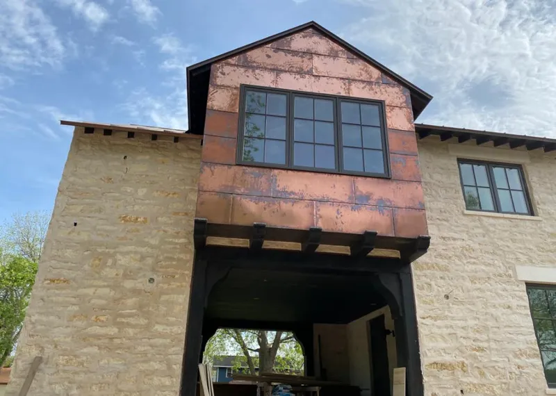 Copper metal panel facade on a stone building for Metal Roof Coating in Eagle